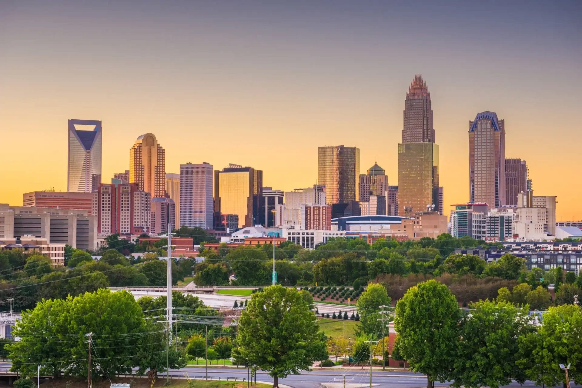 Charlotte skyline with trees and a road, highlighting local businesses and city life in 2026.