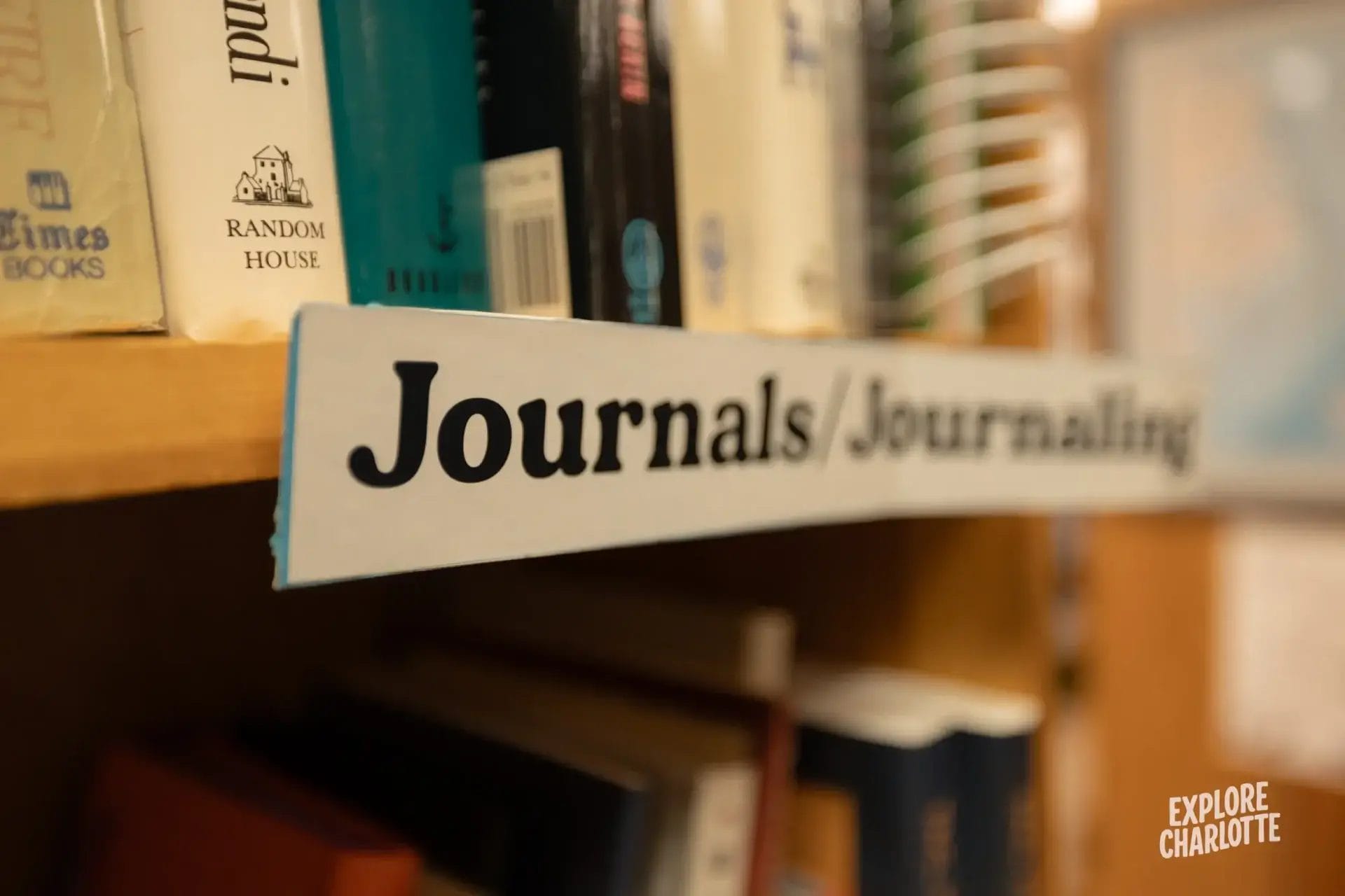 A bookshelf in a Charlotte shop displays books with a small sign, adding to the relaxed local vibe of city life.